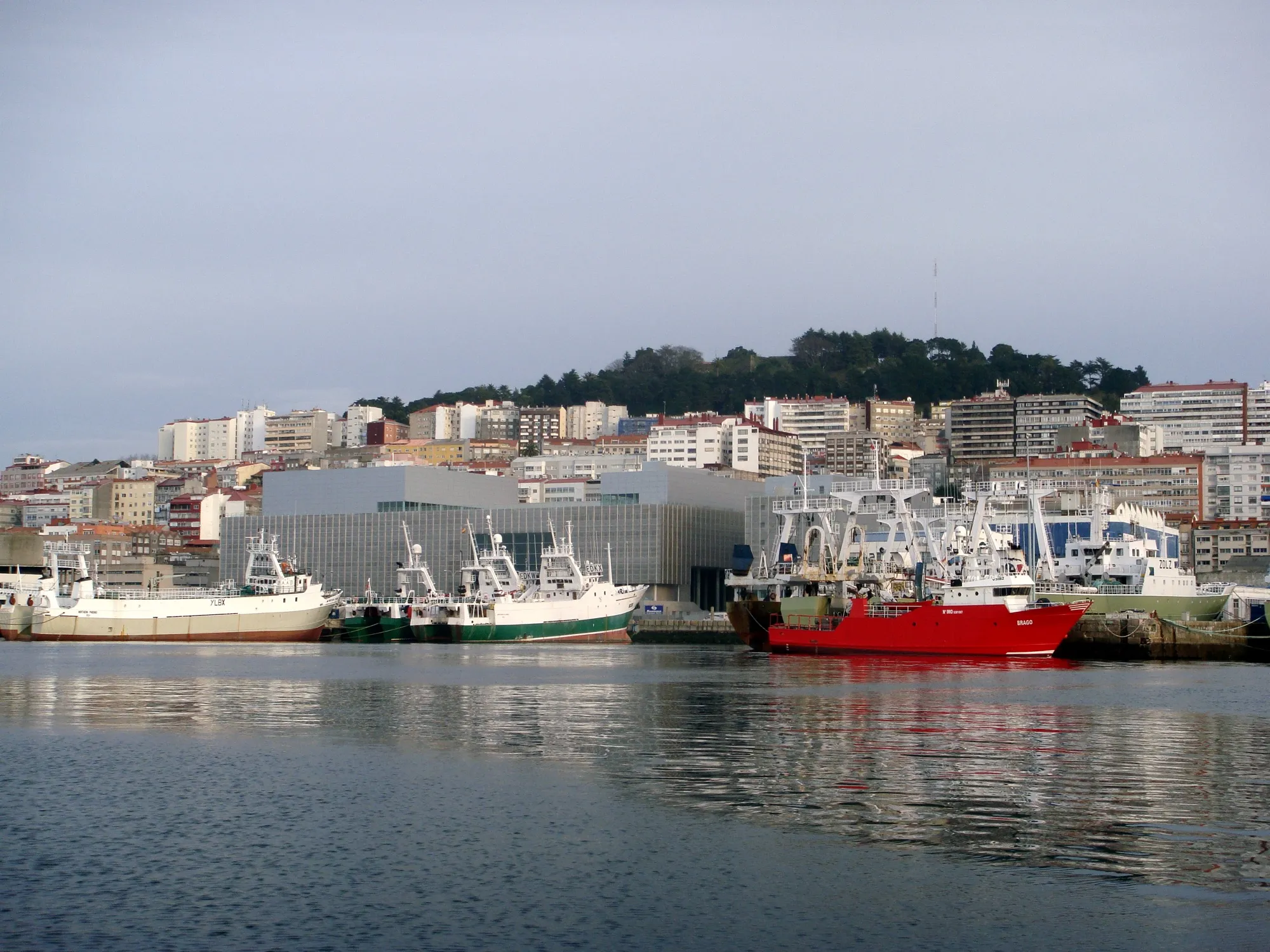 El Auditorio visto desde el agua, entre los barcos del puerto de Vigo